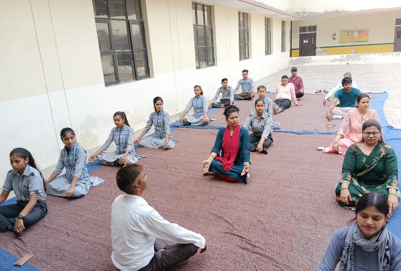Students and teachers in a yoga session in the courtyard